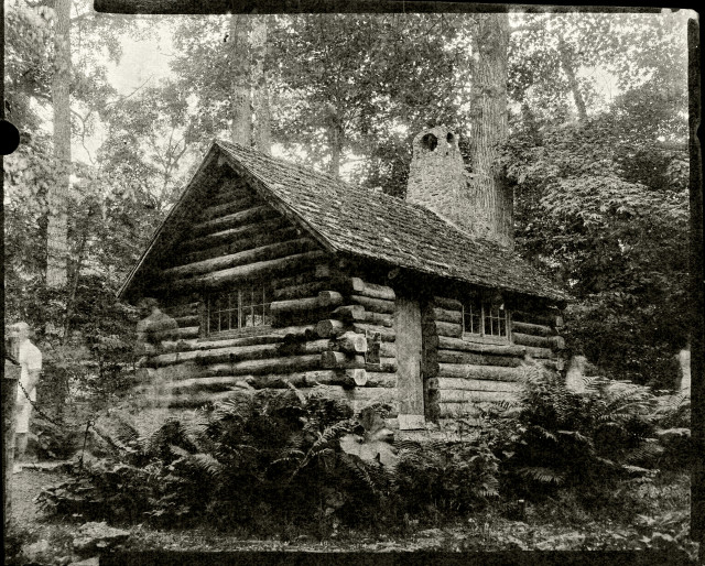 Black and white photo of a log cabin in the woods. It has a very soft texture because of the paper base. There are also some ghost people moving around int he image because I got tired of waiting for there to be no one in front, and figured they wouldn't be too distracting at 15s exposure! 