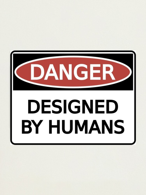 A warning sticker that says Danger: Designed by Humans