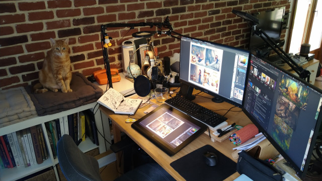 Photo of my workplace with two monitors and a graphics tablet with a built-in monitor (XPPen Artist Pro 16 Gen2) while working on a Mini Fantasy Theater episode a week ago. My cat Noutti is watching the camera from his usual place near my desk.