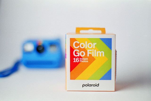 Polaroid Go film box on a white background with the Go camera blurry on the backgorund