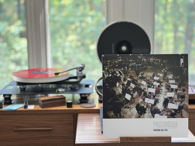 Portishead - roseland nyc live - PNYC LP cover.

A black and white shot of the orchestra hired for the concert in the foreground…with the band in the background. 

The red LP plays on a Rega NAIA turntable to the left.