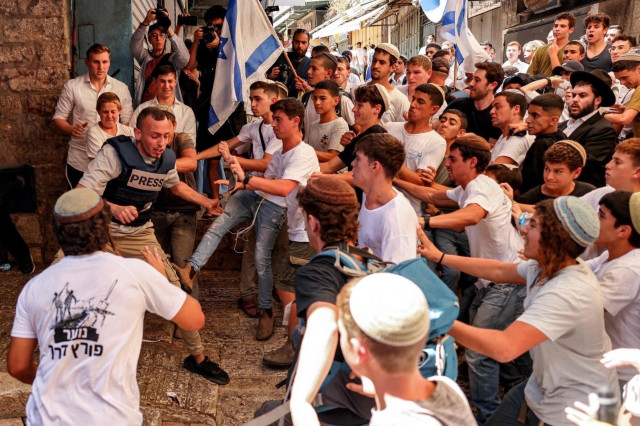 Photo: Israeli fascist youth surrounding and attacking reporter Saif Kwasmi in what looks like an attempted lynching.