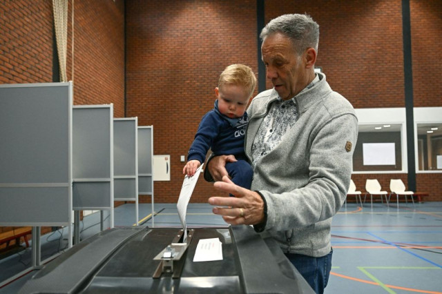 A man with a toddler casts his ballot for the European elections in a polling station, in Baarle-Nassau, south of Netherlands, on June 6, 2024, on the first day of European Parliament election. (Photo by JOHN THYS / AFP) (Photo by JOHN THYS/AFP via Getty Images)