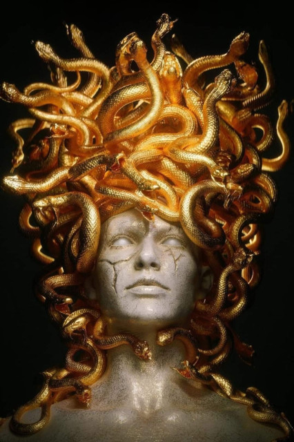 marble statue of medusa with golden snakes on her head