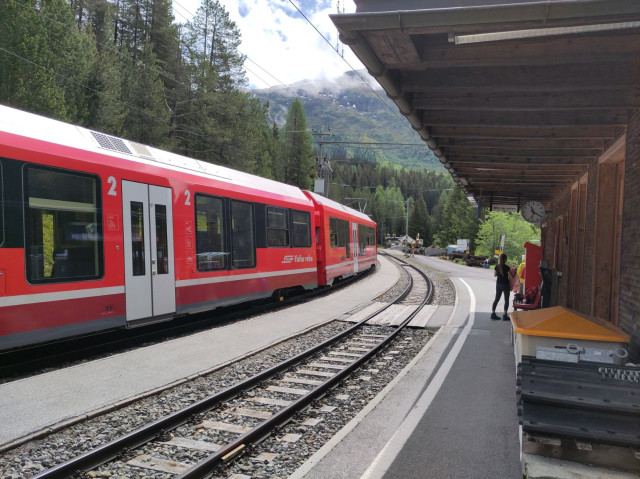 Foto. Ein roter Zug im Bahnhof.