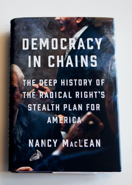 Cover photo: men in dark business suits.

Caption:

"DEMOCRACY
IN CHAINS

THE DEEP HISTORY OF
THE RADICAL RIGHT'S
STEALTH PLAN FOR
AMERICA

[by]

NANCY MACLEAN"