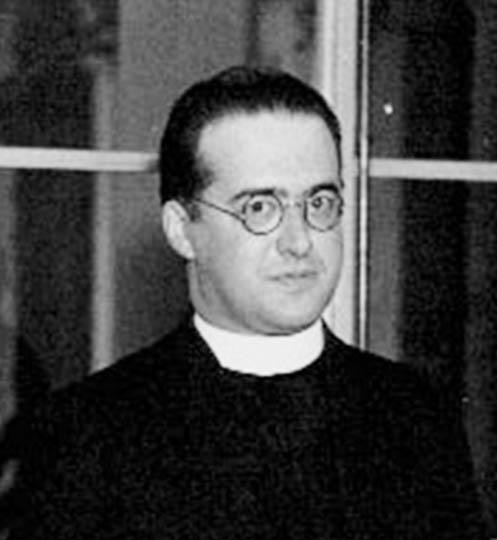 Georges Lemaître
unknown photographer, probably a CalTech employee.

A man in a priest's robe and glasses, standing with a serene expression.