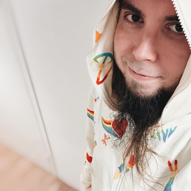 Me with my peace and love onepiece, full of hearts and rainbows. Looking at camera.