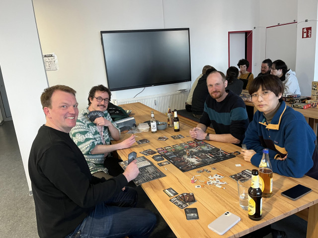 Tuta employees smiling while playing a board game. 