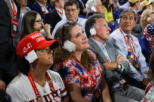 An absurd photo MAGA faithful at the RNC in Milwaukee wearing fake bandages on their ear to emulate their cult leader.