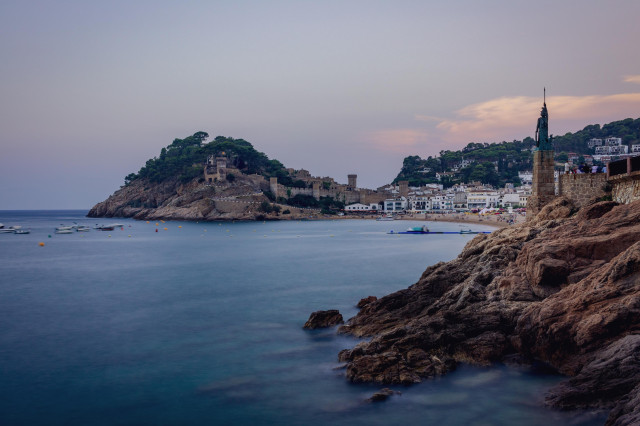 Vista durante el atardecer de la playa y costa del pueblo de Tossa de Mar.