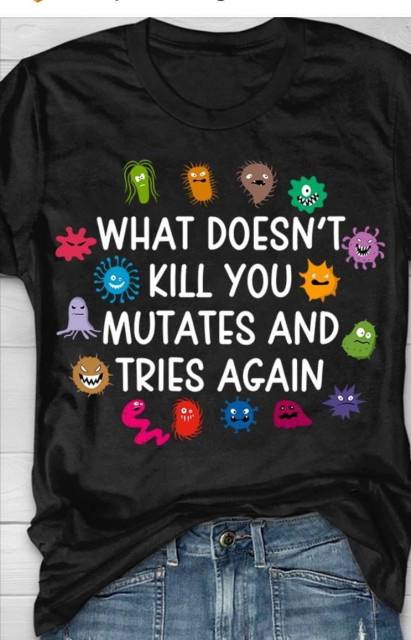 A black t-shirt featuring colorful cartoon germs and microbes surrounding the text: "WHAT DOESN'T KILL YOU MUTATES AND TRIES AGAIN."