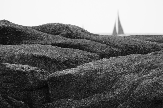 rocks with a sail in the background