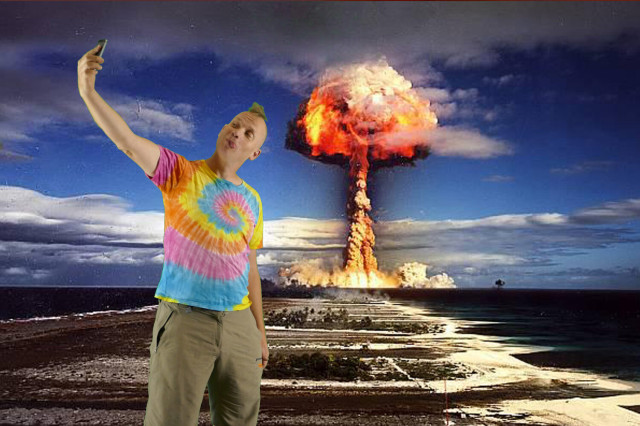 I'm standing in the classic selfie pose and taking a selfie of myself while a mushroom cloud rises in the background. I am inserted into this picture using a green screen in front of the historical shot of an atomic bomb detonation on the Bikini Atoll