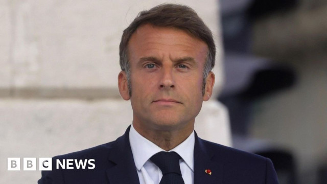 BBC News photo of Macron, in suit and tie, staring at the camera, looking constipated. Sorry, I mean statesmanly.