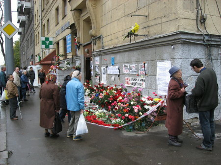 photo of the floral tributes and signs outside Anna's apartment after her murder
