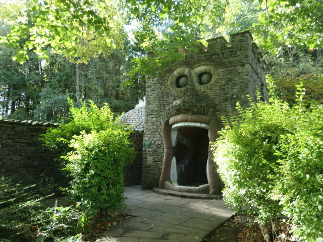 Entrance to Forbidden Corner consisting of a building similar to a castle keep. The keep has a face with two large eyes and a wide open mouth with teeth. It is through the mouth that you enter.