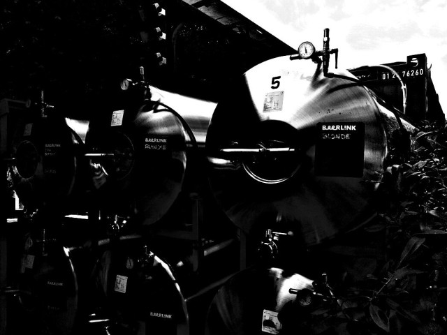 Black and White highly contrasted daylight photo.
Shiny metallic beer reservoirs under pressure waiting for the night release.