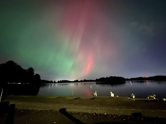 Red green aurora over a lake