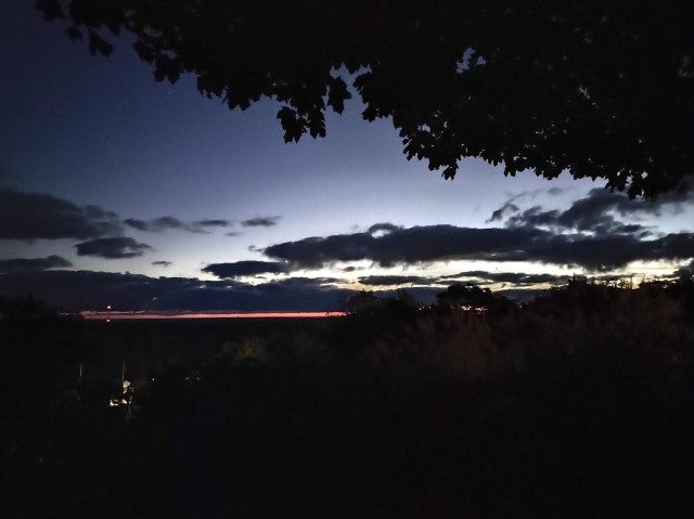 Pre-dawn sunrise with clouds backlit by over-the-horizon scattered sunlight.