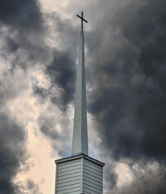 Almost black and white, with hints of grey and blue. A simple, white, country church steeple against raging storm clouds swirling in the background sky.