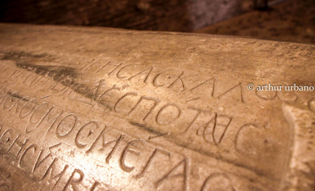 closeup of a marble sarcophagus lid carved with a Greek inscription