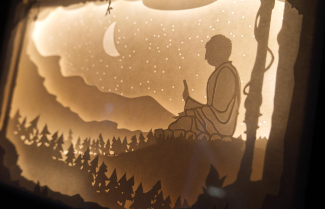 Intricate cut layers of paper stacked in a deep frame. The scene depicted here is of the Tian Tan Buddha in Hong Kong. It's being backlit by LEDs.