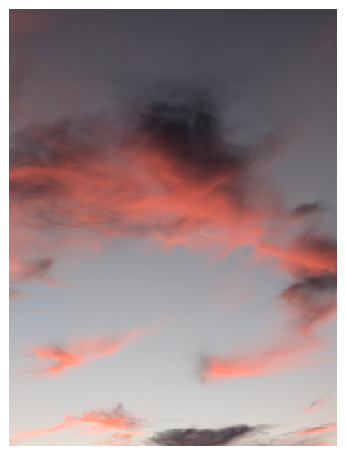 a piece of the sky at sunset with orange/red and charcoal gray clouds.