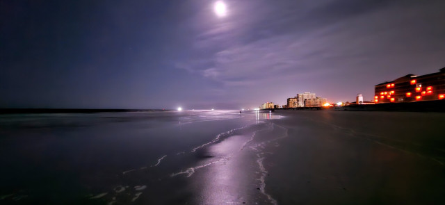 My first view of the waterfront on this excursion. It's still quite dark, but the scene is brightly illuminated by the moon glowing high overhead in the storm cloud filled skies. The moon casts a long beam of light across the water's edge as the surf tide slowly washes in and out on the wet beach sand.