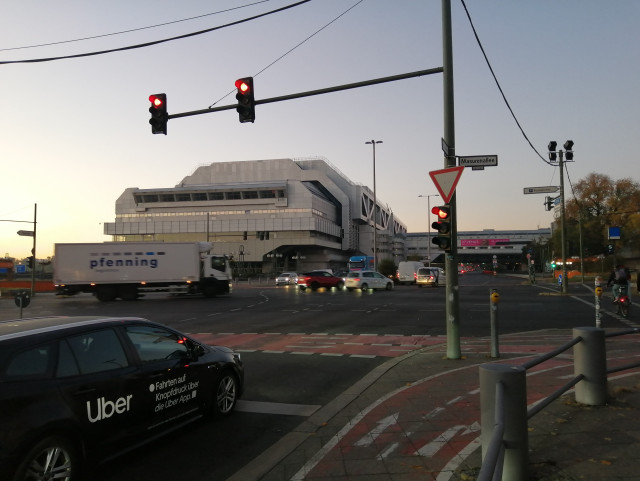 A long, rectangular Aluminium building. Its hull has technical structures.

On the small side, there is a long balcony, somehow resembling a space ship's command bridge window.  