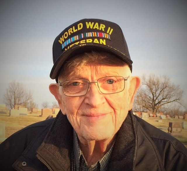 Elderly man in a World War II veteran's hat.