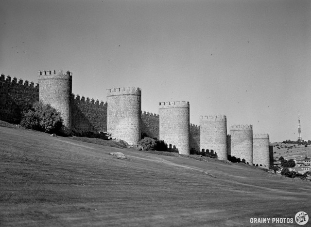 A black-and-white film photo of the wall around the city. The wall is reinforced by a series of round turrets.