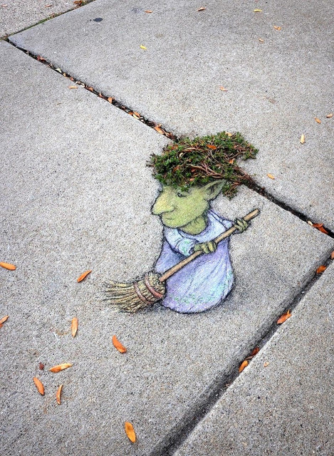 Streetart. A witch (called Frida) was drawn with chalk on a sidewalk. Frida has a greenish skin color, wears a long purple dress and sweeps up narrow orange leaves with her broom. On closer inspection, her wild hair consists of a tuft of green weeds growing out of the cracks between the paving slabs.
Title: "When Frida sweeps the sidewalk, she always leaves a few for the wind to play with."