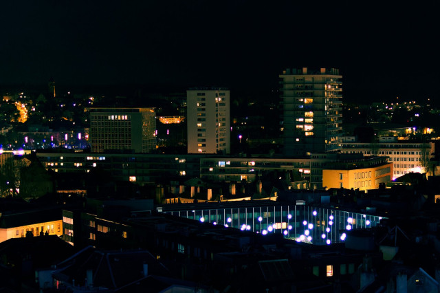 A city at night from an elevated point. There are many lights, that are fighting off the darkness that would like to descent here too.