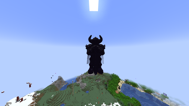 A massive, towering black structure in the shape of a horned figure, situated on the 2b2t Minecraft server. The figure resembles a formidable warrior or demon, with large horns extending upward from its head and broad, wing-like extensions on its back that transition into a smoky white color. The structure's details, including its chest and limbs, are intricately designed, adding depth to the figure's imposing presence. It stands on a grassy hilltop in a diverse biome, surrounded by snowy patches and rivers. The perspective emphasizes the statue's sheer size, making it the dominant feature in the landscape.