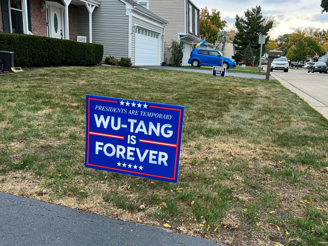 a lawn sign that says presidents are temporary, wu-tang is forever. another sign further back on the lawn for harris/walz