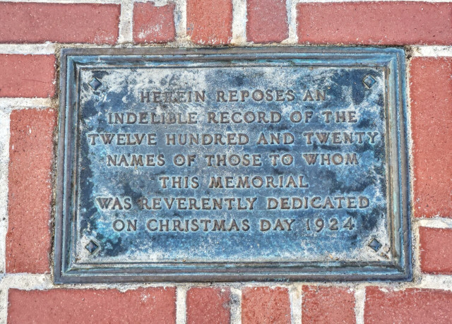 Bronze plaque marking the dedication: 


HEREIN REPOSES AN INDELIBLE RECORD OF THE TWELVE HUNDRED AND TVENTY T NAMES OF those to WHOM THIS MEMORIAL WAS REVERENTLY DEDICATED ON CHRISTMAS DAY 19 2 4