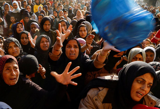 Palestinians gather to buy bread from a bakery in Khan Younis, in the southern Gaza Strip. REUTERS/Mohammed Salem