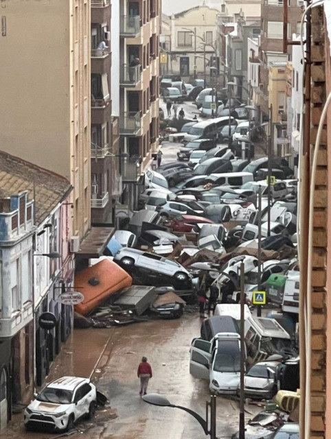 Photo of a street in Catarroja in Valencia with cars piled high between houses, after yesterday’s torrential rains. 