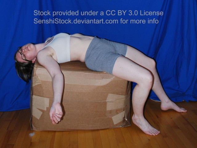 A white woman splayed out "dead" on her back over a cardboard box.