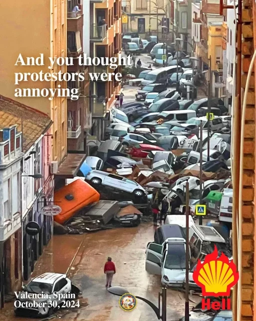 At least 60 cars were picked up by a tsunami of flood water and left jammed together in this narrow street in Spain. It looks like a wrecker's yard. Impossible to walk or drive past this mind-boggling heap.

Text added to the image says "And you thought protestors were annoying." Also "Valencia, Spain, October 30th 2024."

In a corner there is a yellow scallop shell similar to the Shell Company's  logo. It's  surrounded by stylised red flames and the caption says " Hell".