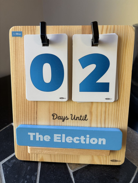 A wooden countdown calendar shows "02 Days Until The Election.