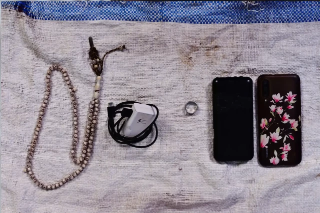 "If I had not sold the photos I took with that phone I would not have got out from Al Renk in South Sudan. These items are placed on the torn plastic bag on which I slept for 23 days. Now it is my prayer carpet." 