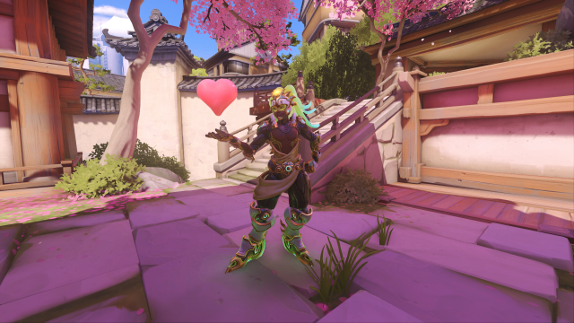 Screenshot of Lucio from Overwatch 2 holding a heart. The background is Hanaoka, a map stylized on Japan. The skin he is wearing is Pacific All-stars 2019.