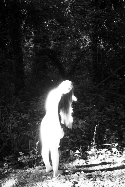 a girl overexposed in monochrome photo of a forest