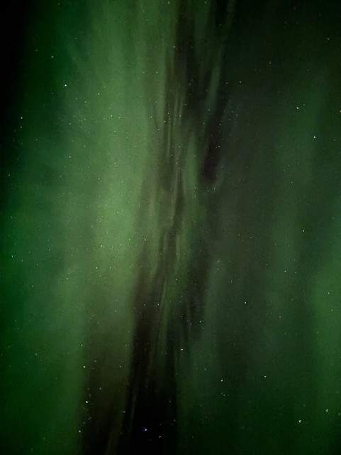 A bright green aurora corona straight above