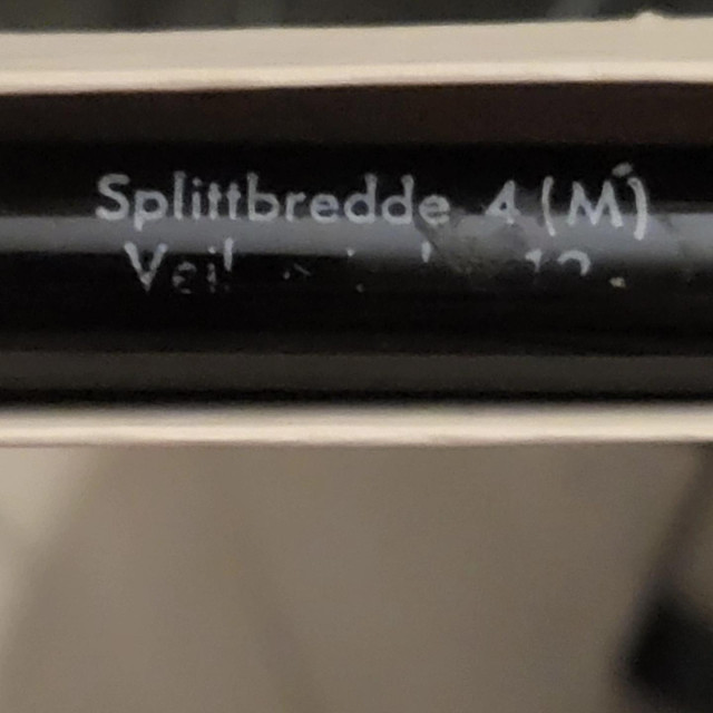 A closeup of the leftmost pen showing markings about the nib size