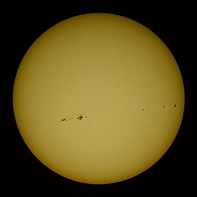 Yellow Sun with spots on a dark background. 