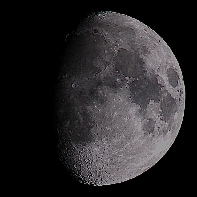 The Moon at waxing gibbous phase on a dark background. 