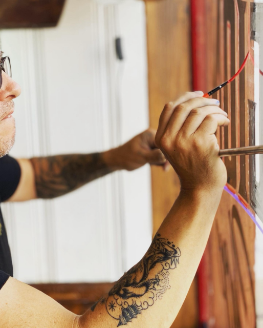 Sam painting a sign on glass at a barbershop